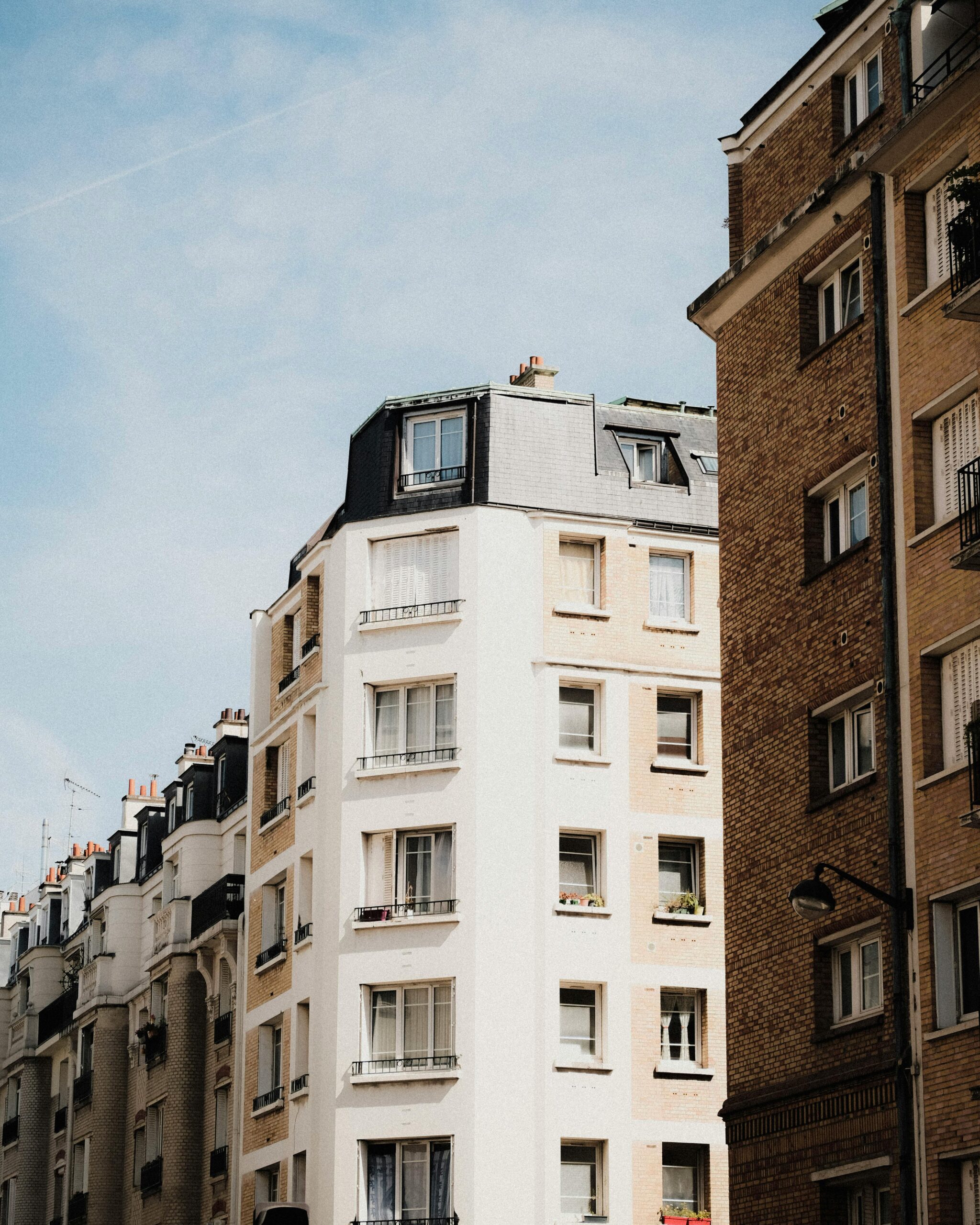 Elegant Parisian townhouses set against a clear blue sky, showcasing classic architecture.